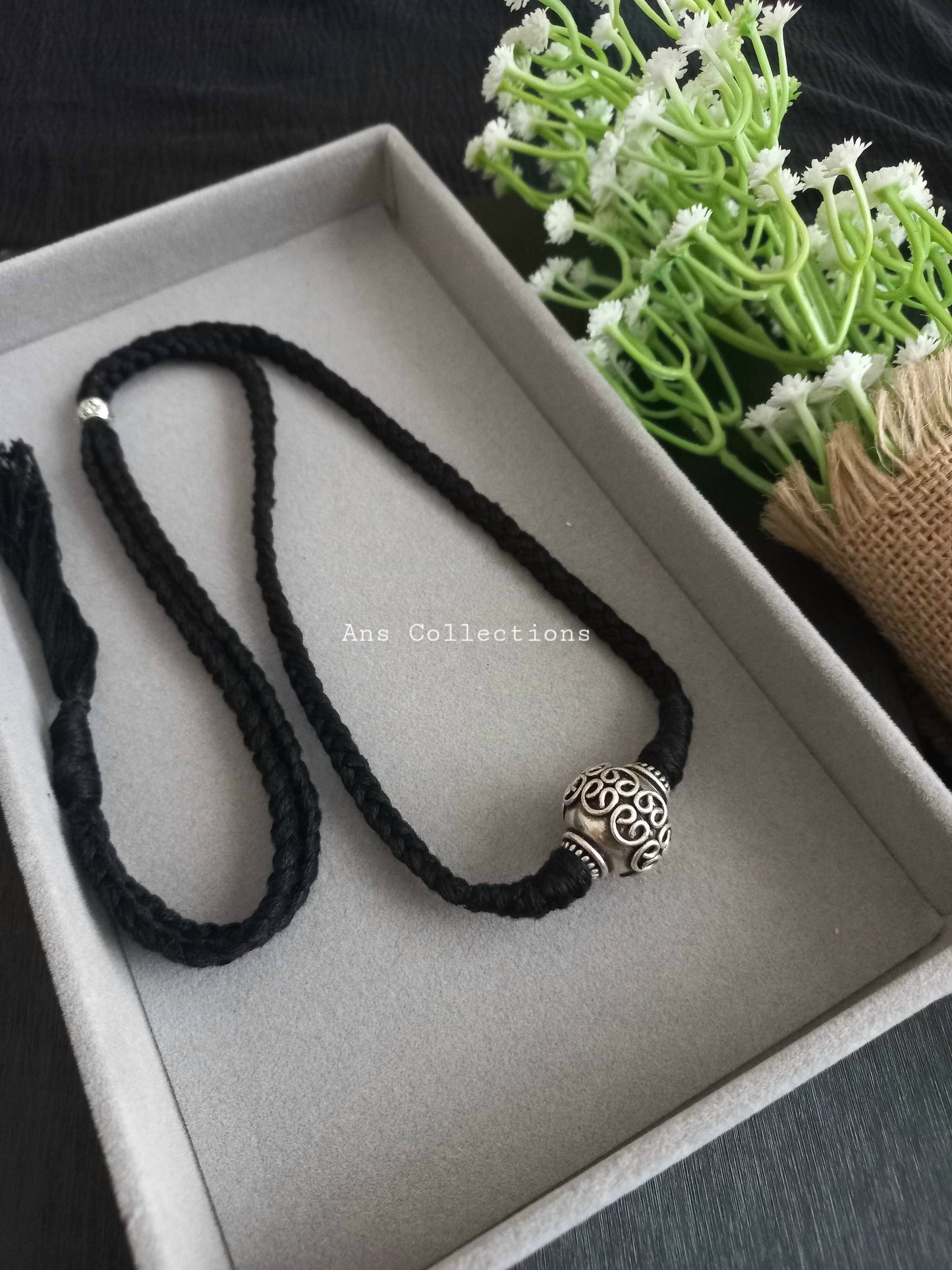 Thread with oxidised bead pendant